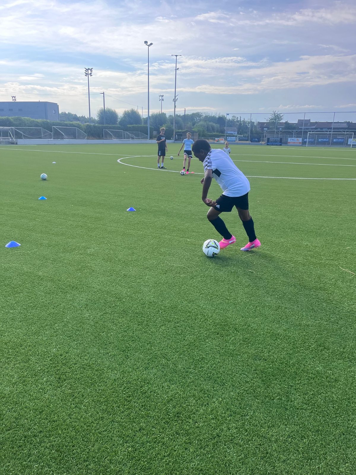 Un enfant dribble entre les plots